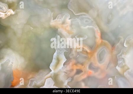 Front view close up of a polished onyx stone with wavy beige and orange mineral layers Stock Photo