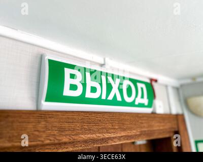 Close up emergency EXIT sign in green color above door. Vihod Stock Photo