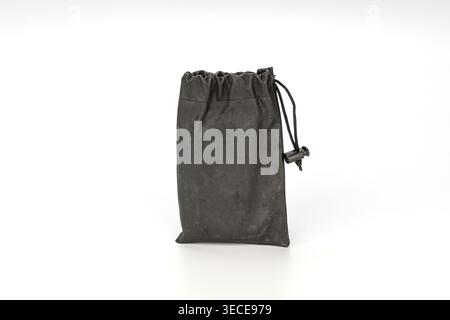 A worn dark gray fabric drawstring pouch bag featuring a black twisted cord with a plastic barrel cord lock stopper closure, photographed isolated on Stock Photo