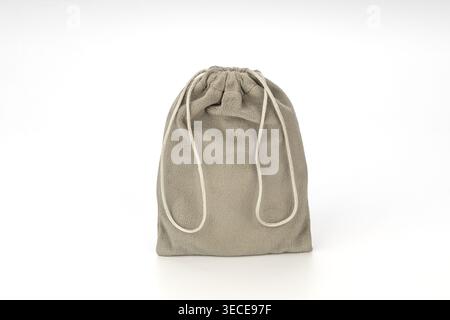 Closed gray microfiber drawstring bag with soft fluffy texture and natural cotton rope ties, isolated on a white background. Ideal for jewelry storage Stock Photo