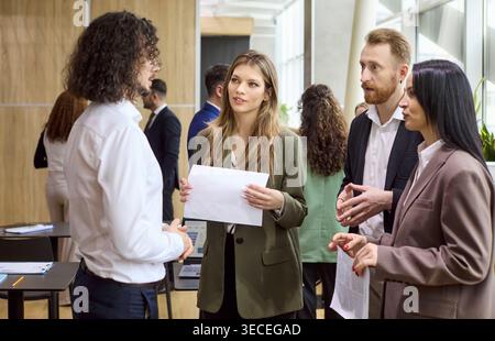 Colleagues in business meeting conversation at networking event in modern office Stock Photo