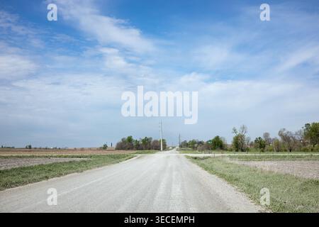 Atkins, Iowa, USA - April 26, 2026: Empty Rural Gravel Road Through Iowa Farmland with Open Sky Stock Photo
