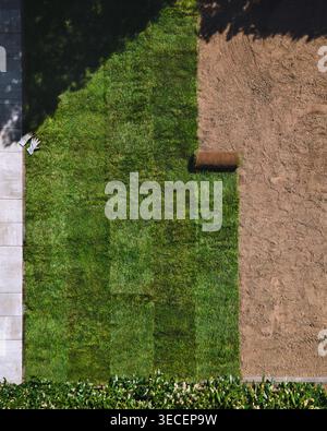 Gardening. Making a lawn from a roll. Green grass texture - well-groomed turf in the garden. View of the garden from above. Stock Photo
