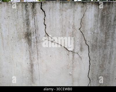 Natural crack pattern on damaged white wall background – textured surface with visible fractures and weathered structure, abstract architectural detai Stock Photo