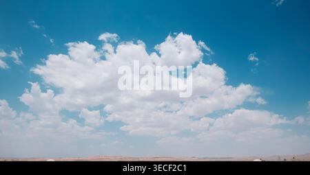 Panorama of blue sky with white fluffy cumulus clouds Stock Photo