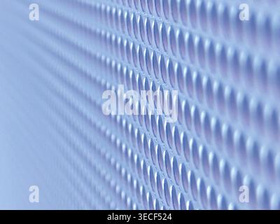 Close-up of shiny perforated metal surface with blurred background and patterned holes Stock Photo