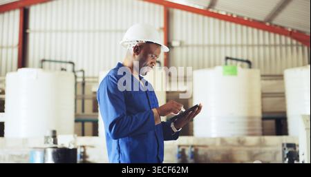 Engineer, man and inspection with tablet, industrial warehouse and checking water system for safety. Serious, inspector and black person with tech for Stock Photo