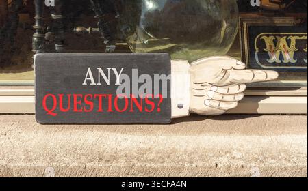 Any questions symbol. Concept words Any questions on beautiful wooden black sign as a hand. Beautiful store display background. Business and Any quest Stock Photo