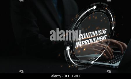 Business Professional Working on Laptop with Focus on Continuous Improvement Concept in Dark Environment Sigmoid Stock Photo