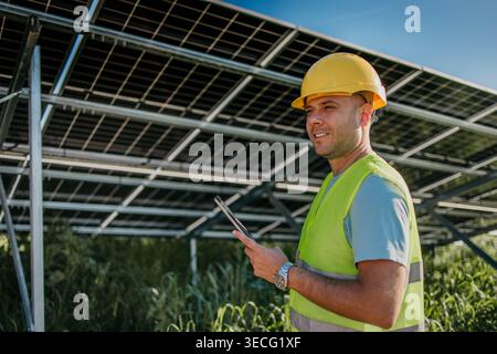 Man is working with solar panels outdoors at daytime Stock Photo