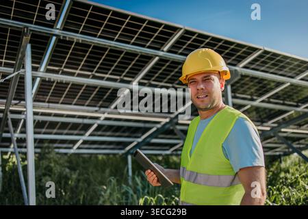 Man is working with solar panels outdoors at daytime Stock Photo