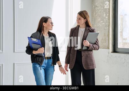 Two successful professional businesswomen colleagues talking together in office Stock Photo
