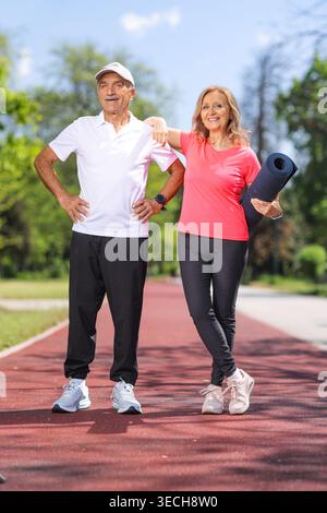Senior couple standing on a running track after an outdoor workout Stock Photo