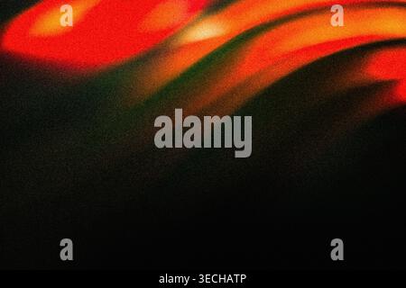 Abstract background featuring dramatic grainy red and orange glowing light waves on black Stock Photo