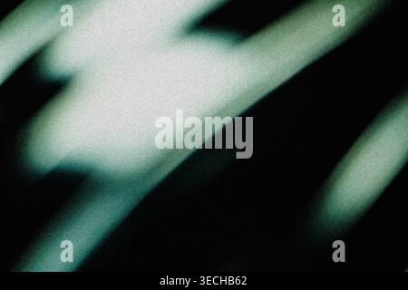 Blurred bright teal and white diagonal light streaks crossing dark grainy background Stock Photo