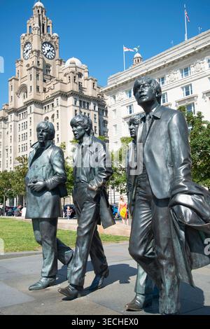 Liverpool,United Kingdom-August 10 2022:Summertime along the city center Waterfront,the lifelike Beatle statues stand permanently,attracting visitors Stock Photo