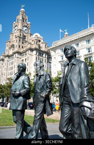 Liverpool,United Kingdom-August 10 2022:Summertime along the city center Waterfront,the lifelike Beatle statues stand permanently,attracting visitors Stock Photo