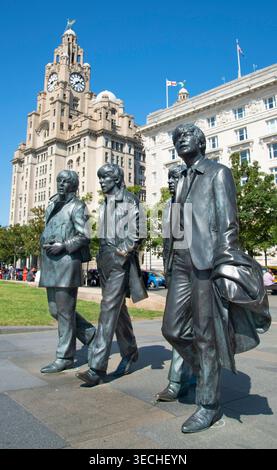 Liverpool,United Kingdom-August 10 2022:Summertime along the city center Waterfront,the lifelike Beatle statues stand permanently,attracting visitors Stock Photo