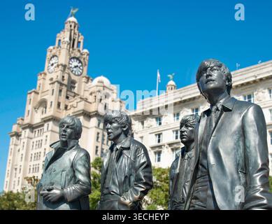 Liverpool,United Kingdom-August 10 2022:Summertime along the city center Waterfront,the lifelike Beatle statues stand permanently,attracting visitors Stock Photo