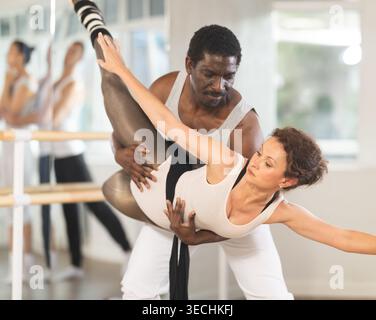 African American male dancer supporting ballerina in graceful dip Stock Photo