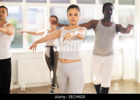 Concentrated women and men rehearsing ballet dance in class Stock Photo