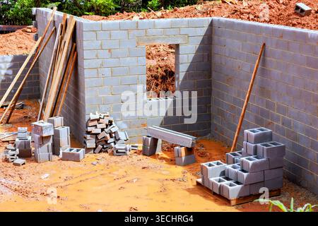 Building work in progress with gray cement blocks stacked on ground tools placed near works site Stock Photo