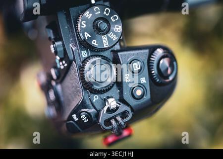Closeup of black digital camera mode dial and control buttons showing texture detail and design with shallow depth of field Stock Photo