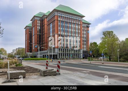 Amsterdam, Netherlands, April 24, 2026. Wide shot of the UWV headquarters building featuring distinctive brickwork and green pitched roofs under a clo Stock Photo