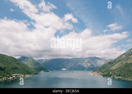 Magnificent atmospheric patterns spreading across calm lake near hills Stock Photo