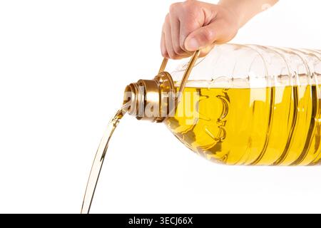Hand pouring vegetable cooking oil from plastic bottle Stock Photo