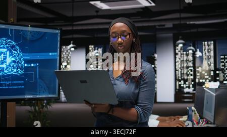 Programmer in office developing complex machine learning algorithms simulating human brain thought processes. IT professional deploys AI tools, performing software quality assurance Stock Photo