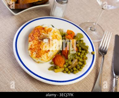 Plate of bacalhau (salted cod) fillet served with portion of stewed ...