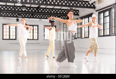 People practicing vigorous lindy hop movements in dance class Stock Photo