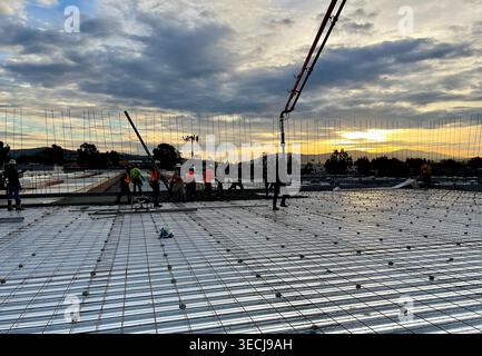 Construction workers pouring concrete slab at a commercial job site Stock Photo