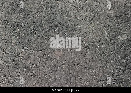 Macro horizontal full frame background texture of dark grey asphalt road surface with rough fine grain pattern Stock Photo