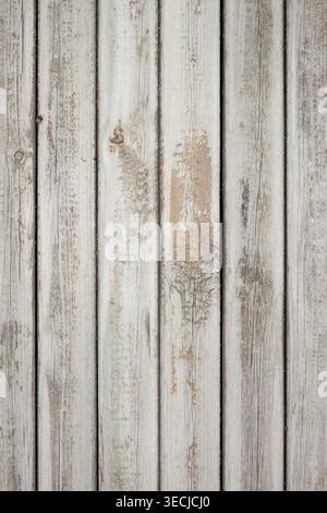 Macro vertical full frame background texture of old shabby painted grey wooden fence planks with peeling paint and knots Stock Photo