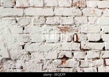 Macro horizontal full frame background texture of old shabby painted white brick wall surface with visible cracks Stock Photo