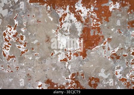Macro horizontal full frame background texture of shabby weathered grey concrete wall surface with red paint flakes Stock Photo