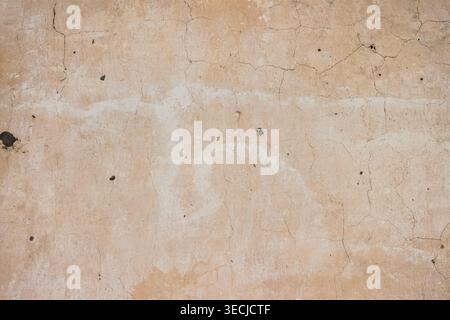 Macro horizontal full frame background texture of light brown cracked plaster wall surface with dirty spots Stock Photo