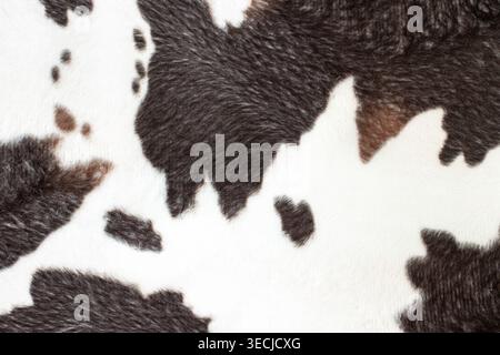 Macro horizontal full frame background texture of artificial cow skin fur with brown and black spots on white base Stock Photo