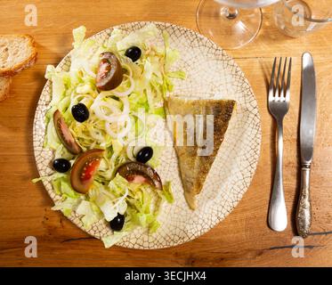 Plate of bacalhau (salted cod) fillet served with portion of stewed ...