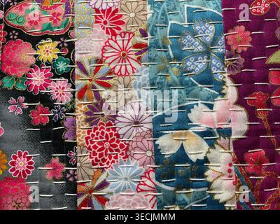 Colorful Japanese textile samples featuring floral patterns with sashiko-style running stitches in decorative patchwork arrangement Stock Photo