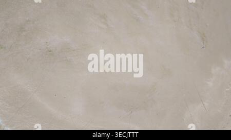 Light beige plaster or concrete wall texture background with subtle stains, scratches and trowel marks, minimalist neutral surface with copy space. Stock Photo