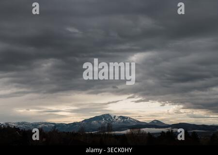 Dark storm clouds over distant snow-covered mountains in Utah Stock Photo