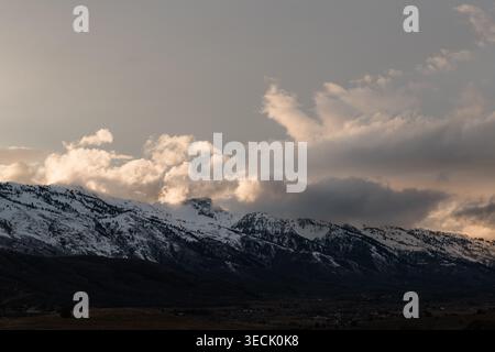Storm clouds gathering over snowy mountain rang sunset Stock Photo
