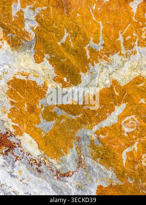 Close-up abstract stone texture showing vivid orange and gray mineral veins, natural weathered surface details and organic pattern, ideal as backgroun Stock Photo