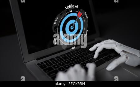A robotic hand engages with a laptop, presenting a digital target on the screen that signifies achievement and innovation in modern business Stock Photo