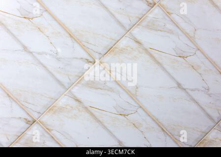 Close up view of light gray ceramic floor tile texture with beige veining patterns forming diagonal grid layout creating calm and neutral interior sur Stock Photo