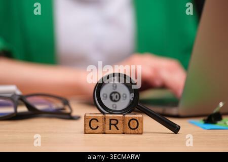 Exploring conversion rate optimization with magnifying glass and wooden blocks on a desk during a productive work session Stock Photo