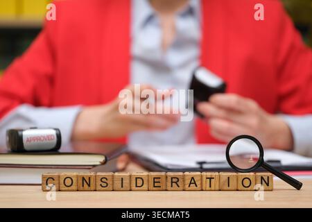 In a bustling office, a professional reviews documents with focus, surrounded by personal notes and tools that enhance thoughtful decision-making. Stock Photo